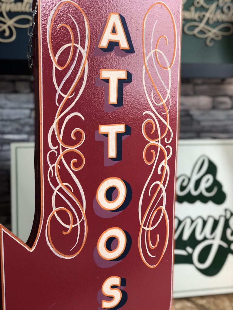 Handpainted hang sign for a tattoo shop