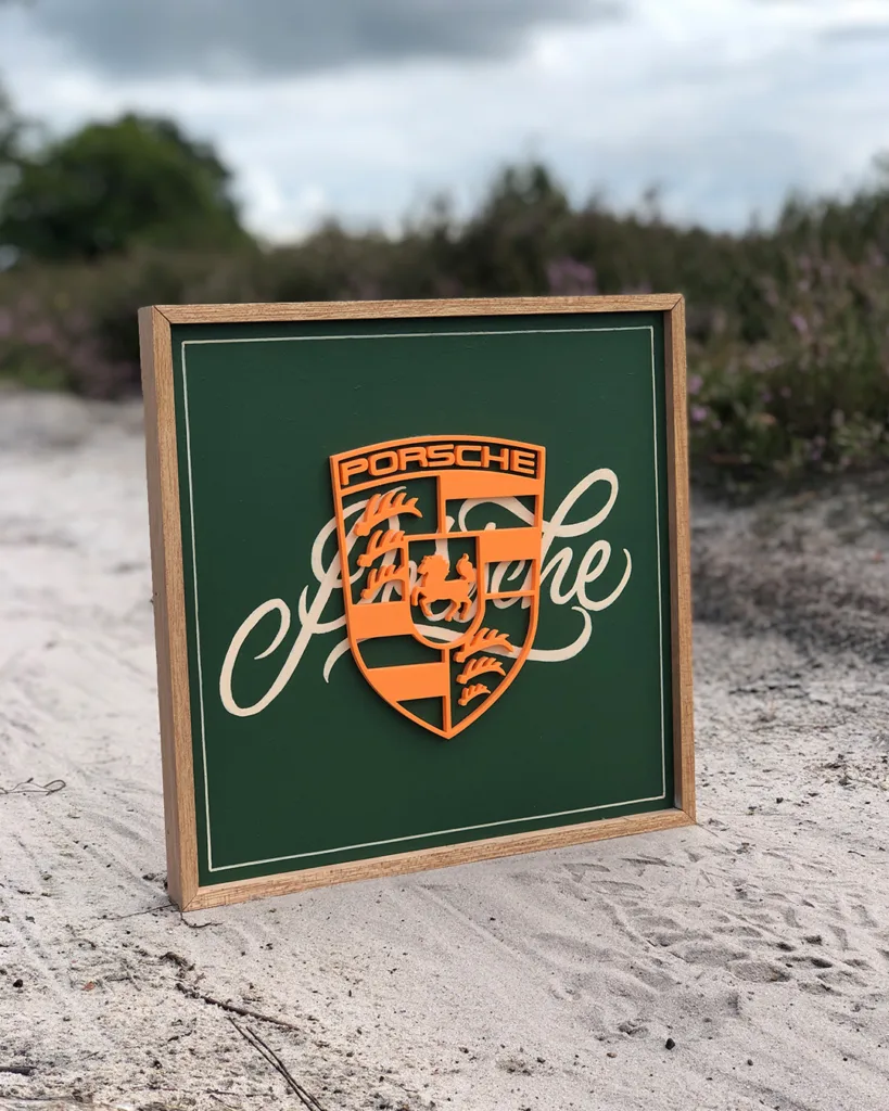 Houten bord met handgeletterde Porsche-typografie en een 3D-geprint Porsche-logo in reliëf