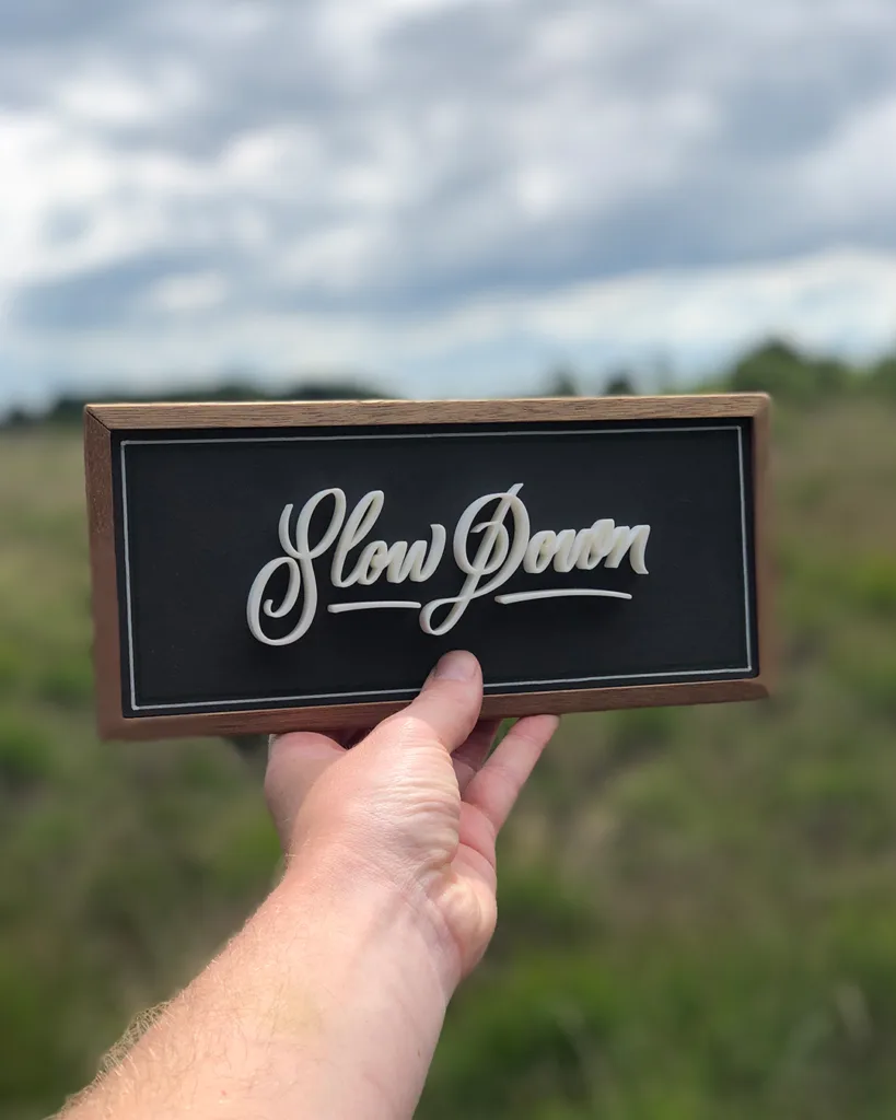 3D-geprinte kalligrafie met de tekst “Slow Down” in een vloeiend, ambachtelijk letterontwerp