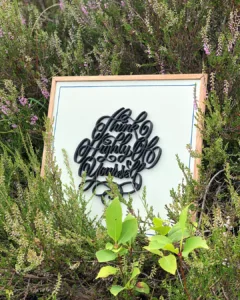 Sierlijke 3D-geprinte kalligrafie in Spencerian Script met de tekst “Think Highly of Yourself” op een houten bord