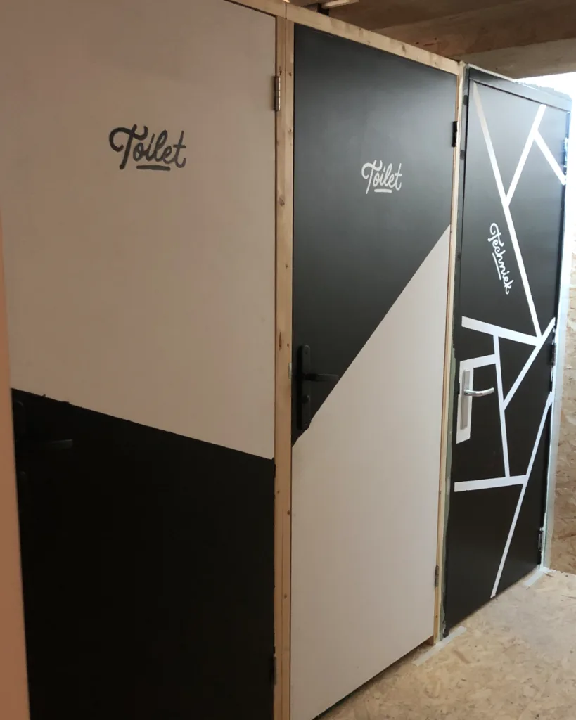 Handgeschilderde deurbelettering voor coworking space Nordgard in Groningen, uitgevoerd met monoline script letters en contrasterende zwart-witte vlakken.