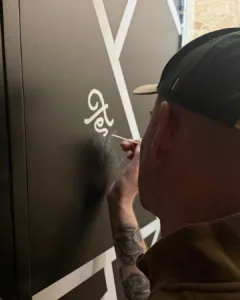 Handgeschilderde deurbelettering voor coworking space Nordgard in Groningen, uitgevoerd met monoline script letters en contrasterende zwart-witte vlakken.